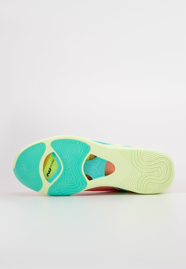 Zapatilla deportiva con suela verde menta, texturizada para mayor agarre. Presenta una sección cortada que revela el acolchado interior en tonos pastel.