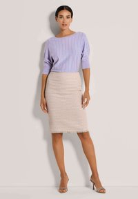 Helles lila ribbed Strickoberteil mit Bootsausschnitt, kombiniert mit einem beigen, strukturierten Bleistiftrock, der einen fransigen Saum und eine schmale Passform aufweist.