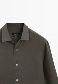 Mørke olivengrøn hørskjorte med knapper, krave, tre synlige knapper og mærkelabel syet indvendigt i kraven.