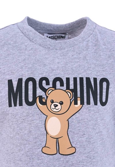Szara bawełniana koszulka z czarnym logo "MOSCHINO" oraz grafiką kreskówkowego misia z beżowymi i białymi akcentami, z teksturowaną okrągłą szyją.