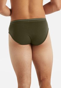 Slip da uomo verde oliva realizzati in tessuto morbido, con una ampia fascia elastica in vita con un accento grigio chiaro, vestibilità aderente e texture liscia.