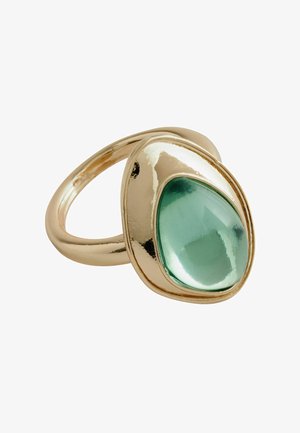 Bague en or avec une grosse pierre précieuse verte, lisse et en forme de goutte, sertie dans un large anneau métallique poli.