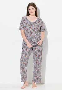 Leopardenmuster-Pyjama-Set aus weichem Stoff, bestehend aus einem kurzärmligen Oberteil mit U-Boot-Ausschnitt und einer Hose mit elastischem Bund. Die Farben umfassen lila und rote Akzente.