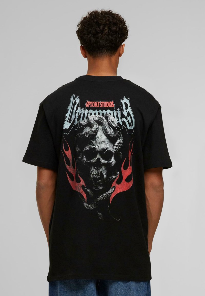Sort bomulds t-shirt med et stort grafisk motiv på ryggen af et kranium viklet ind i slanger og flammer, med slidt tekst ovenfor.