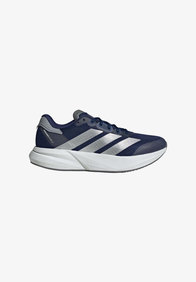 Námořní běžecká obuv s kovovými stříbrnými pruhy, síťovinovým svrškem, šedými akcenty, polstrovanou bílou podešví a texturovanými detaily na svršku.