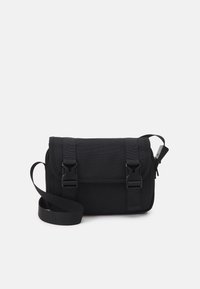 Borsa a tracolla nera realizzata in tessuto con superficie testurizzata. Presenta due chiusure a fibbia regolabili e una tracolla removibile.