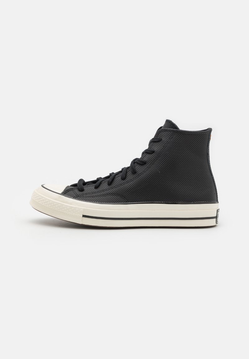 Black high-top sneaker with mesh texture, white rubber toe cap, flat laces, and contrasting white stripe along the sole.