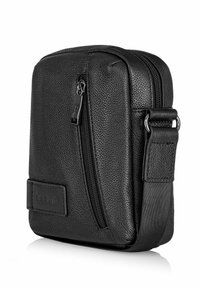 Czarna torebka ze skórzaną fakturą, z przednią kieszenią na zamek, regulowanym paskiem i naszywką z logo. Kształt kwadratu z gładkimi krawędziami.