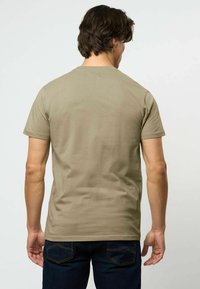 Alyvuogių žalios spalvos trumpomis rankovėmis marškinėliai, pagaminti iš medvilnės, su apvaliu kaklu ir glotnia, minkšta tekstūra, be matomų raštų ar akcentų.