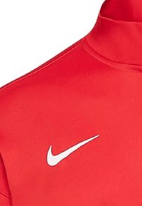 Rood Nike-hoge kraagtop gemaakt van soepel stof, met een wit Nike swoosh-logo aan de linkerkant. Eenvoudig, passend ontwerp.