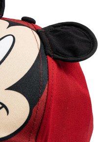 Cappellino da baseball rosso con un grande design del volto di Topolino. Include decorazioni nere per le orecchie e un tessuto strutturato con dettagli di cucitura visibili.