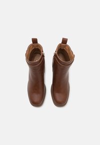 Hnědé kožené kotníkové boty s hladkým povrchem, kulatou špičkou a bočním zipem. Mají krátký lem a malou poutko pro snadné obouvání.