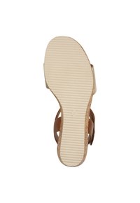 Brune lædersandal med en tekstureret lysbeige gummisål. Har et ribbet mønster og størrelse 37-mærkning på bunden.