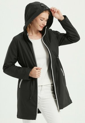 Veste légère noire avec capuche, accents de fermeture éclair blanche et cordons de serrage à la taille. Texture lisse avec un design jusqu'aux genoux.