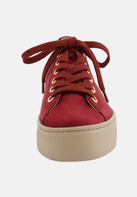 Sneaker rossa in pelle con punta rotonda, occhielli dorati e lacci piatti marroni. Presenta una suola in gomma beige con grip testurizzato.