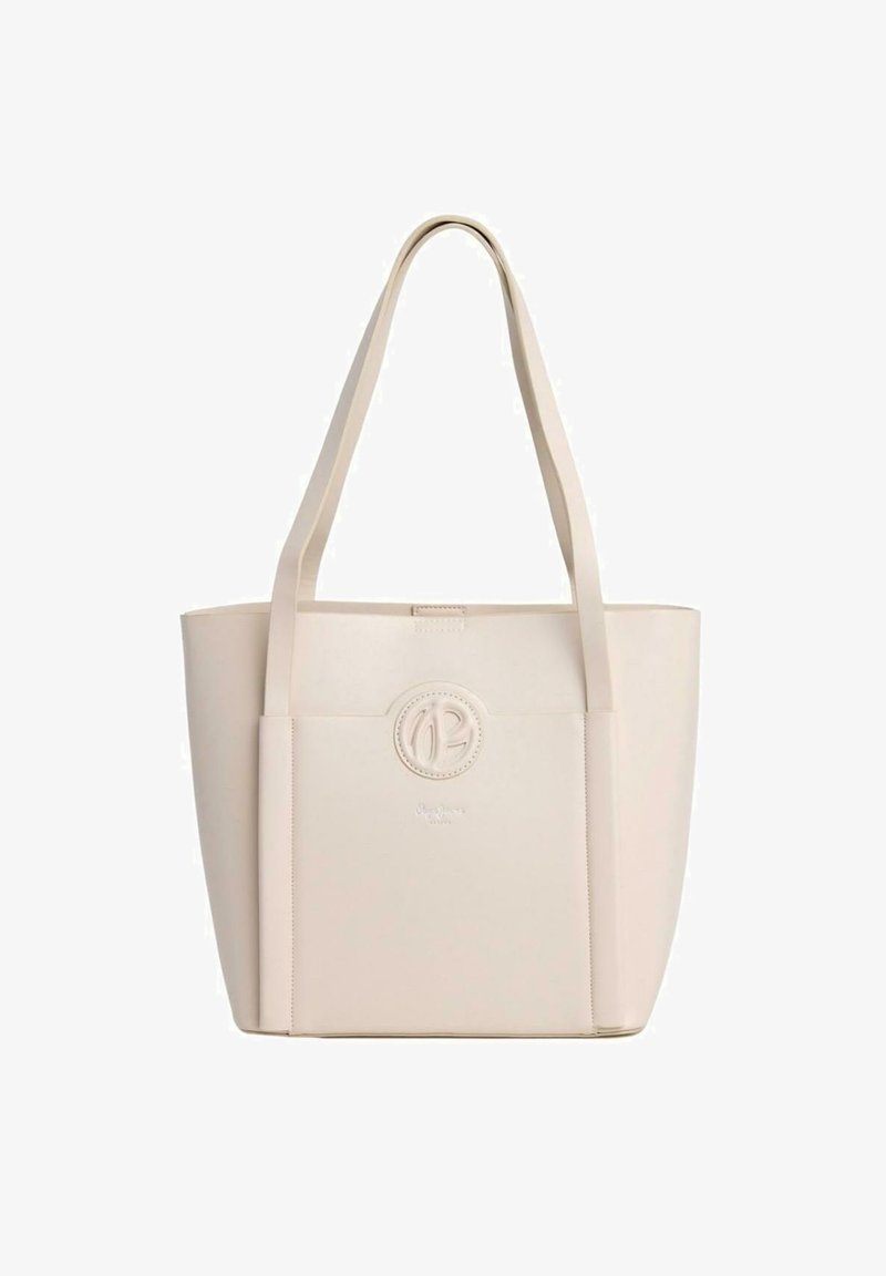 Bolso tote de material sintético suave en color beige, con dos asas largas, un logo circular en relieve en la parte frontal y una forma rectangular plana.