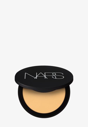 Fond de teint poudre compacte dans un boîtier rond noir avec un couvercle partiellement ouvert montrant un produit beige clair et le logo NARS sur le dessus.