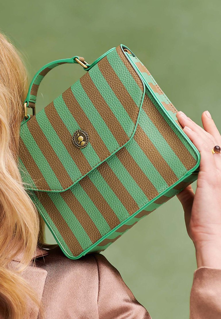 Green and brown striped handbag with a textured finish, fold-over flap, circular gold hardware, and a short handle for carrying.