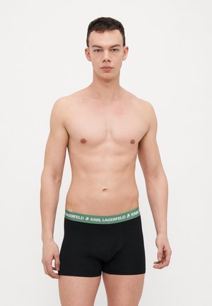Boxers negros con una cinturilla verde que presenta la etiqueta "KARL LAGERFELD". Diseño minimalista, material de algodón suave y ajuste de cintura media.