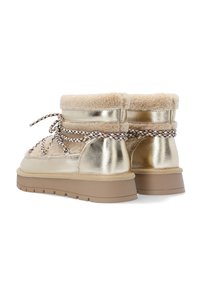 Guldmetallic støvler med et skaft af fårskind, med et tekstureret mønster og en brun gummisål. Snørebåndene er brune og hvide vævede.