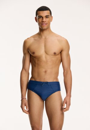 Navy blue swim briefs made of smooth fabric with a drawstring waistband, featuring a snug fit and minimalistic design.