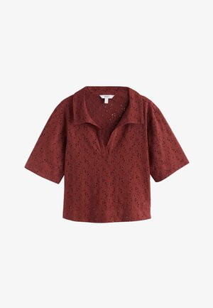 Rövid ujjú rozsda vörös lyukacsos felső nyitott gallérral és virágmintás kivágásokkal.