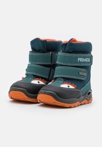Teal barne støvler med oransje detaljer, gummisåle, borrelåser og dekorative øyne og tenner design på forsiden. Vanntett materiale.