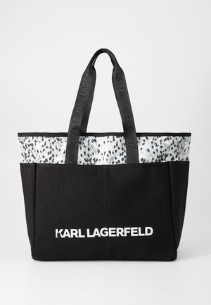 Svart totebag med et mønstret grått toppbånd og teksturerte svarte sider, med doble svarte håndtak og hvit "KARL LAGERFELD" merkevare.
