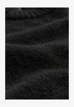 Schwarzer Wollstoff mit einer weichen, flauschigen Textur, der verschiedene Webmuster und sanfte Kurven aufweist und ein geschichtetes Aussehen erzeugt.