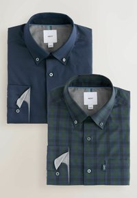Due camicie con colletto di NEXT: una di colore blu navy solido, l'altra a quadri verdi e blu navy. Entrambe presentano dettagli con bottoni e polsini interni a contrasto.