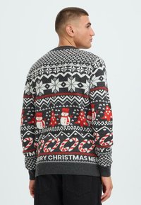 Knit sweater in gray with festive patterns including snowflakes, snowmen, and candy canes in red and white accents. Ribbed cuffs and hem.