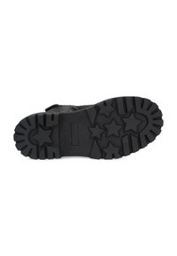 Suela de goma negra con patrón de estrellas y textura de superficie. Presenta un diseño plano para mayor tracción y durabilidad.