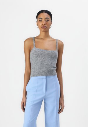 Grå strikket crop-top med smale stropper, sammen med lyseblå høyhøyde bukser som har en slank passform og glatt tekstur.