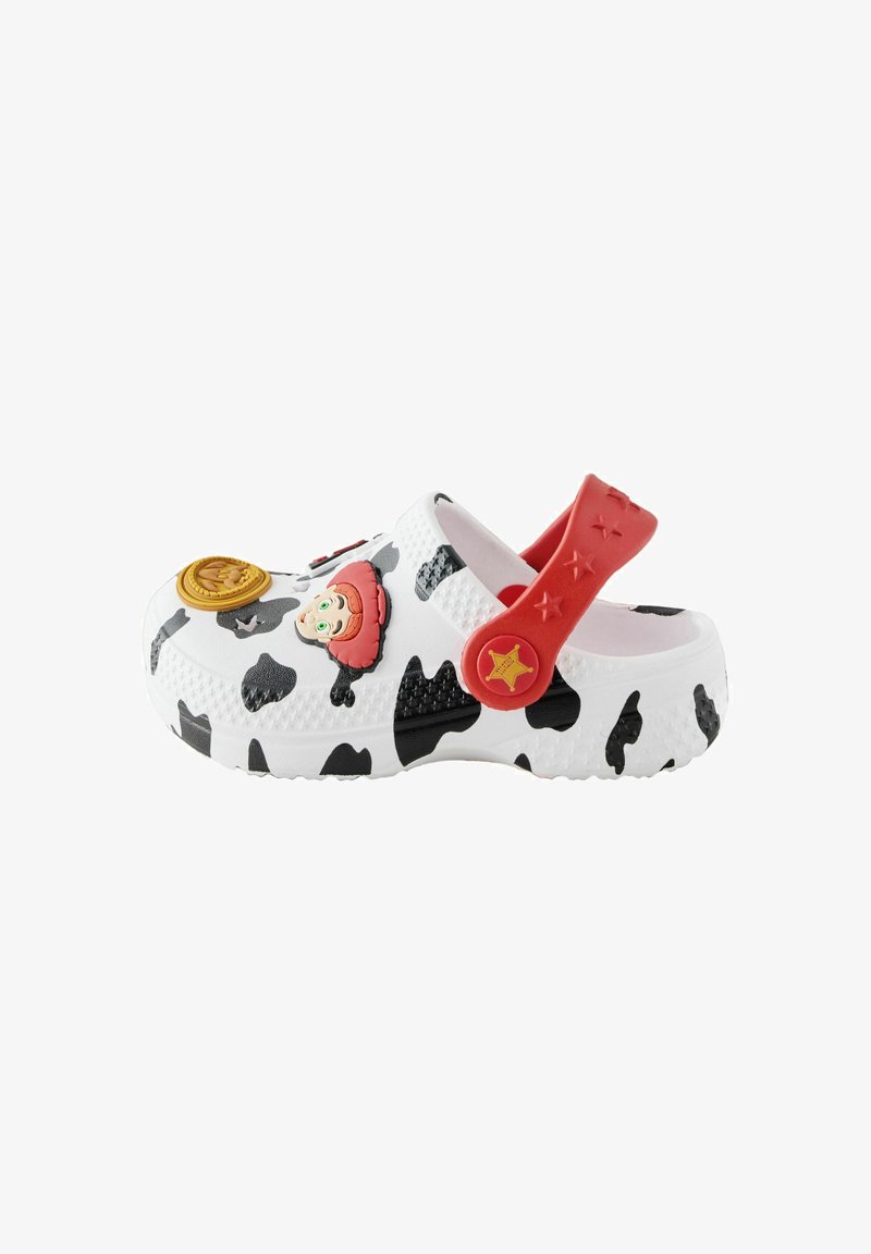 Sabot pour enfant avec imprimé vache noir et blanc, bride réglable rouge, et décorations de chapeau de shérif et badge dessin animé sur fond blanc.
