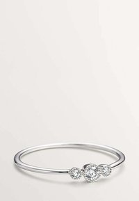 Anillo de plata con tres gemas redondas y transparentes, diseñado de manera minimalista. Banda suave con un acabado pulido, que resalta las piedras.