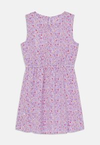 La robe florale présente un fond lilas avec des motifs de fleurs colorés, une coupe sans manches, une taille froncée et une fermeture par bouton à l'arrière.