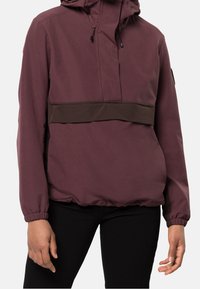 Veste à capuche bordeaux avec une bande élastique marron à la taille, dotée de poignets élastiques, d'une demi-fermeture éclair à l'avant et d'une finition texturée.