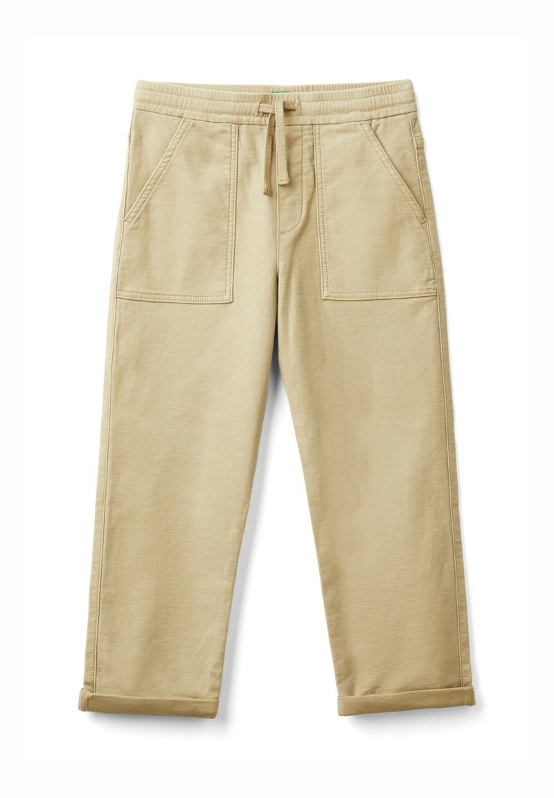 Beige cotton joggers with an elastic waistband, drawstring, and two front pockets; cropped length with rolled cuffs. Soft texture.