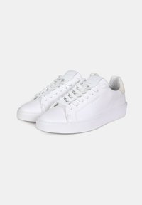 Sneakers bianchi in pelle con suola piatta, punta rotonda e lacci tono su tono. Presentano un accentuazione testurizzata sul tallone e dettagli di cuciture minime.