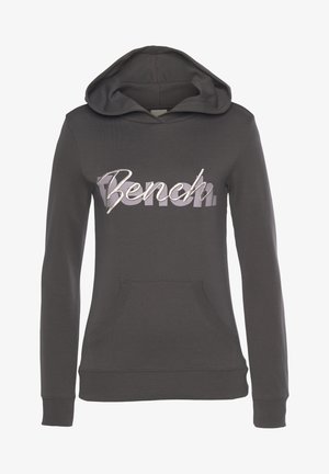 Grauer Kapuzenpullover aus weichem Material. Verfügt über eine Fronttasche und ein großes, metallisch silbernes "Bench"-Logo auf der Brust.