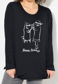Schwarzes Langarmshirt mit weißen Umrissillustrationen von zwei Lamas, die Hüte tragen, und dem Text "Frohe Feiertage" darunter. Weicher Stoff.
