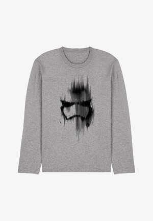 Graues Langarm-T-Shirt mit schwarzem abstraktem Grafikdesign, das eine stilisierte Figur darstellt, mit weicher Stoffstruktur und Rundhalsausschnitt.