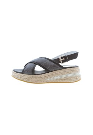 Sandalo con zeppa espadrille nera realizzato in tessuto intrecciato, con fasce incrociate e fibbia regolabile alla caviglia, dotato di una piattaforma in juta e suola in gomma.
