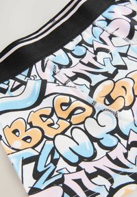 Spalvinga grafika spausdinta medžiaga, kurioje ryškūs žodžiai šviesiai mėlyna, oranžine ir rausva spalvomis ant baltos pagrindo. Juodas elastingas juosmuo viršuje.