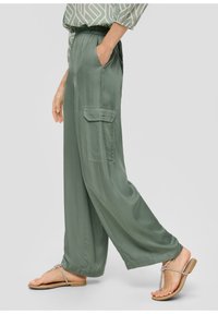 Ljust gröna vidbyxor i en silkeslen textur, elastisk midja, sidofickor och en ficka på benet. Matcher med platta sandaler.