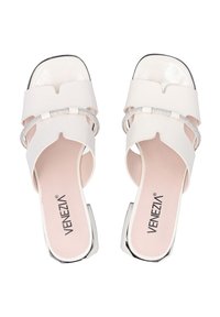 Witte open-toe sandalen met brede banden, metalen accenten en een gestructureerde binnenzool. De zool heeft een subtiele glans en een lage hak.