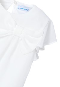 Abito bianco con colletto, maniche corte volantee e un grande fiocco in vita. Il tessuto appare leggero e liscio.