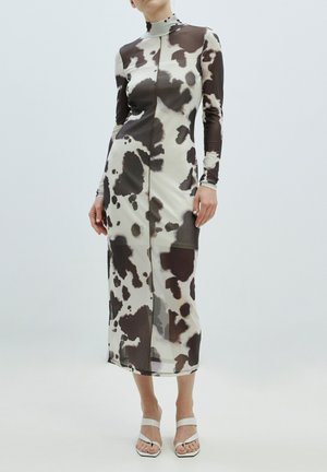 Langärmliges Kleid in einem cremen und braunen abstrakten Kuhmuster, mit hohem Ausschnitt, slim fit und bodenlanger Silhouette.