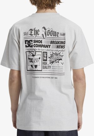 Gray cotton t-shirt with a newspaper-style graphic print on the back featuring black text and illustrations, including a rabbit character and logos.