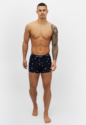 Marineblaue Boxershorts mit einem Blumen- und Sternmuster, aus weichem Stoff gefertigt, mit einem elastischen Bund, der "HAPPY SHORTS" beschriftet ist.